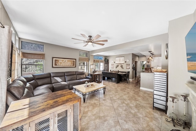 living room featuring a healthy amount of sunlight, light tile patterned floors, ceiling fan, and baseboards