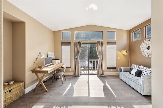 office space featuring lofted ceiling, baseboards, and wood finished floors