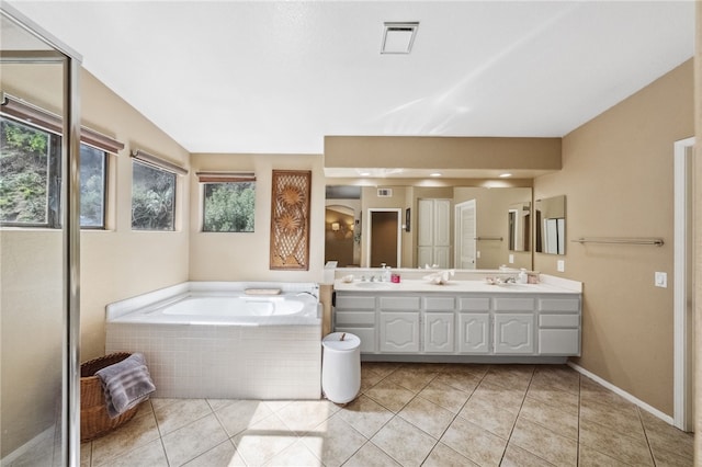 full bath with double vanity, visible vents, a bath, tile patterned flooring, and a sink