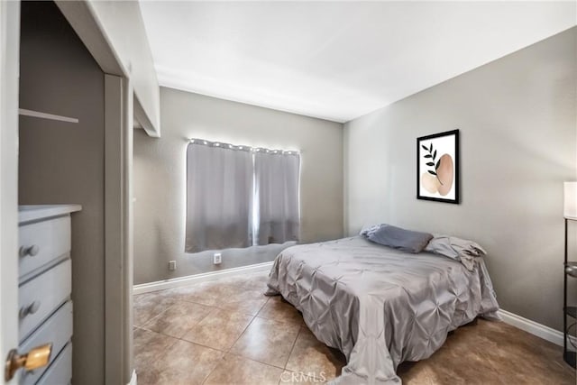 bedroom with baseboards and light tile patterned flooring