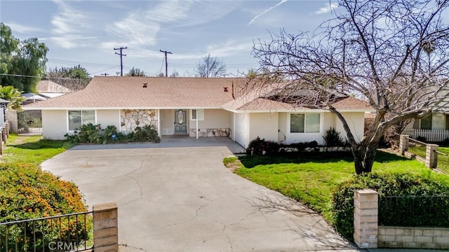 single story home with concrete driveway, a front yard, fence, and stucco siding