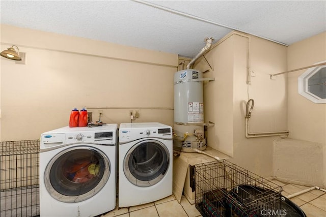 laundry room with laundry area, light tile patterned floors, independent washer and dryer, a textured ceiling, and water heater