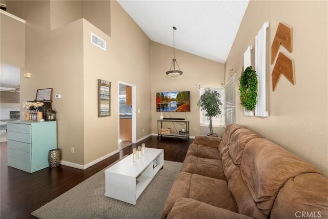 living area with dark wood-style floors, baseboards, visible vents, and high vaulted ceiling