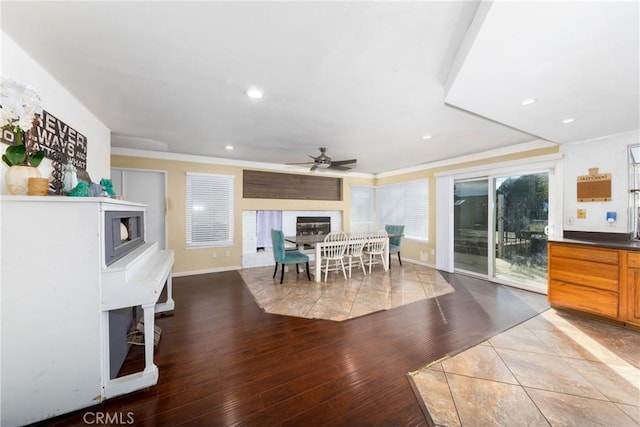 dining space featuring recessed lighting, a ceiling fan, wood finished floors, and a glass covered fireplace