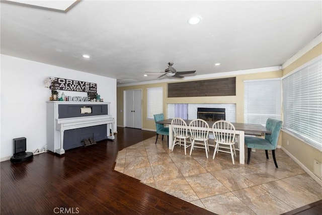 dining space featuring a fireplace, recessed lighting, a ceiling fan, wood finished floors, and baseboards