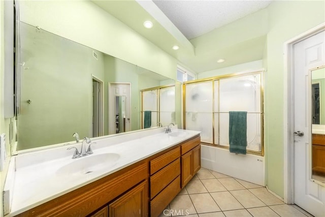 full bathroom with double vanity, tile patterned flooring, combined bath / shower with glass door, and a sink