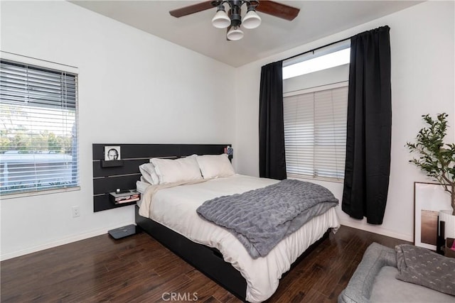 bedroom with dark wood-style flooring, ceiling fan, and baseboards