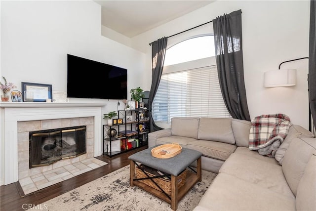 living area featuring a tiled fireplace and wood finished floors