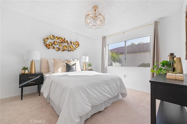 bedroom with a textured ceiling, baseboards, a chandelier, and light colored carpet