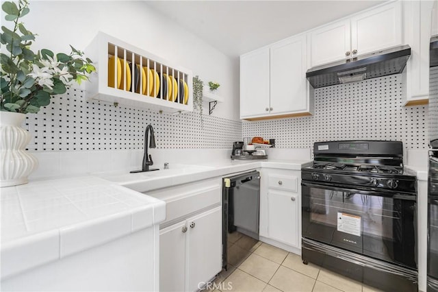 kitchen featuring light tile patterned floors, under cabinet range hood, white cabinetry, tile counters, and black appliances