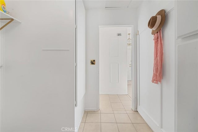 hallway with light tile patterned floors and baseboards