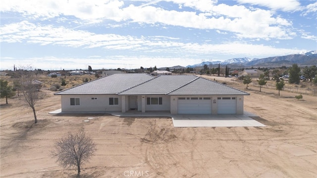 ranch-style house with stucco siding, a mountain view, a garage, driveway, and a tiled roof