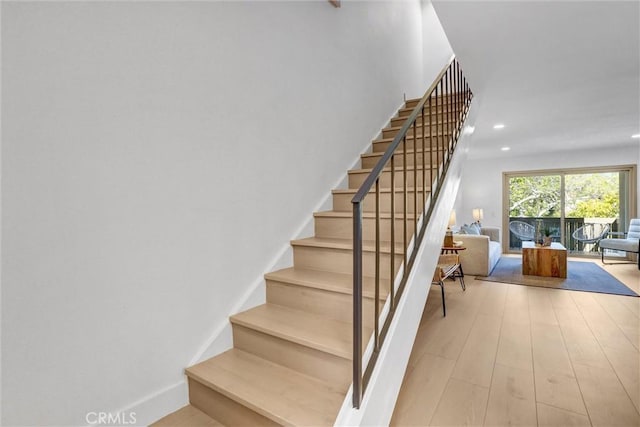 staircase featuring recessed lighting, wood finished floors, and baseboards