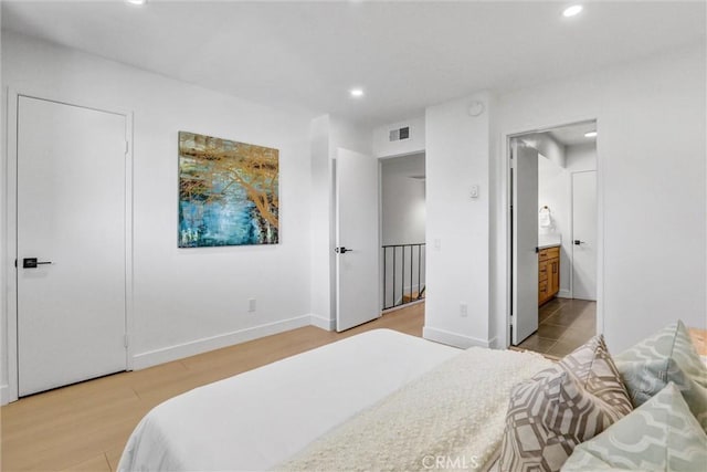 bedroom featuring light wood-type flooring, visible vents, ensuite bath, recessed lighting, and baseboards