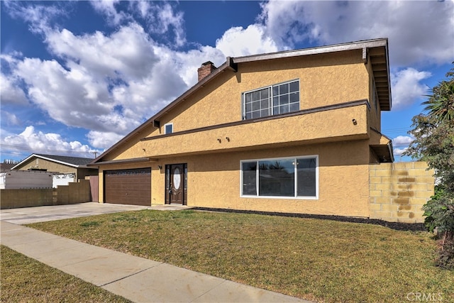 view of front of home featuring a front yard, fence, a chimney, and stucco siding