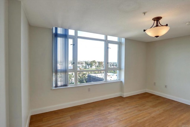 empty room with light wood-type flooring and baseboards