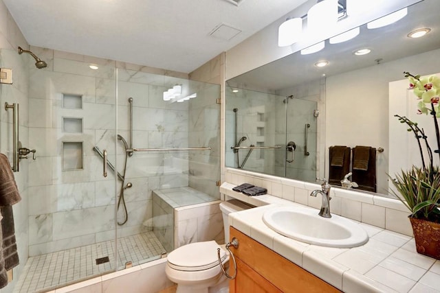 bathroom featuring a stall shower, vanity, and toilet