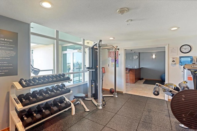 workout area with recessed lighting, a textured ceiling, and baseboards