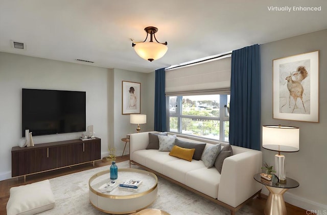 living room featuring baseboards, visible vents, and wood finished floors