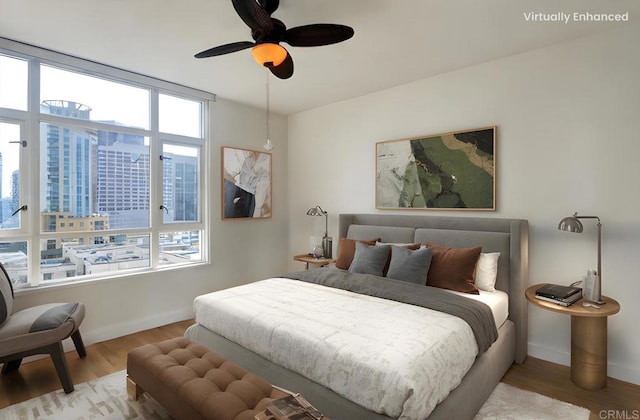 bedroom with a ceiling fan, baseboards, and wood finished floors