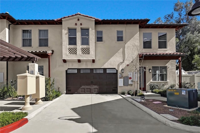 mediterranean / spanish house featuring an attached garage, a tile roof, concrete driveway, and stucco siding