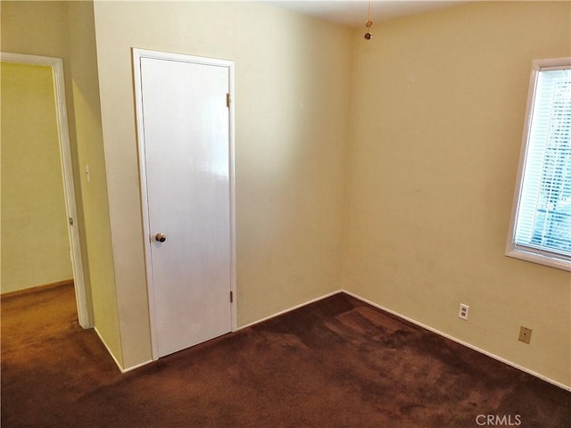 empty room featuring dark carpet