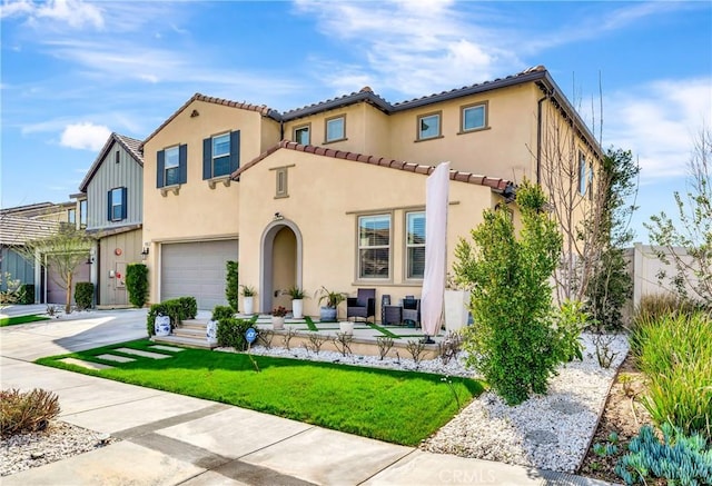 mediterranean / spanish-style home with a garage, concrete driveway, a tiled roof, a front lawn, and stucco siding