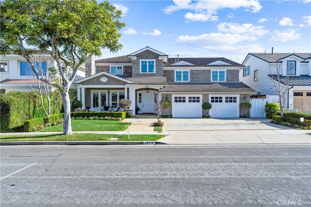 view of front of home with an attached garage, a front lawn, and concrete driveway