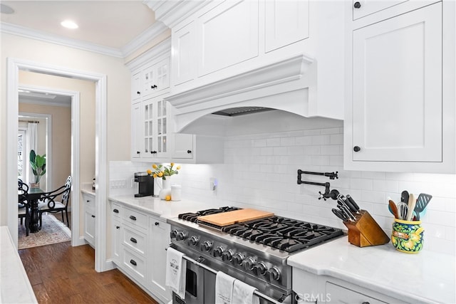 kitchen with light countertops, range with two ovens, white cabinetry, and crown molding