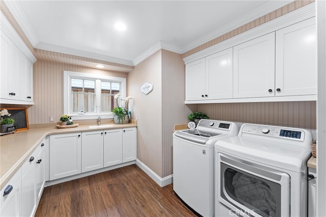 laundry room with a sink, ornamental molding, independent washer and dryer, cabinet space, and dark wood-style floors