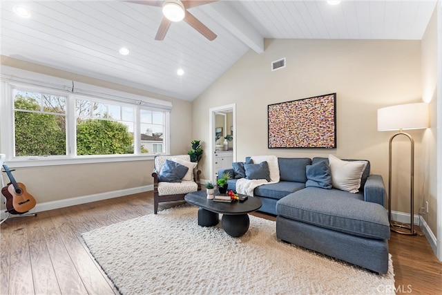 living room with visible vents, vaulted ceiling with beams, baseboards, and wood finished floors