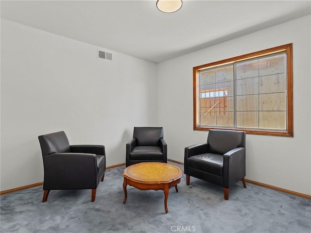 sitting room with carpet floors, visible vents, and baseboards