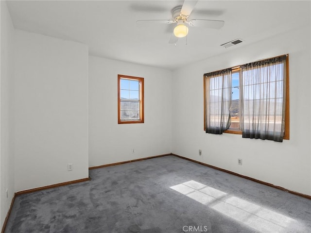 unfurnished room featuring carpet floors, baseboards, visible vents, and a ceiling fan