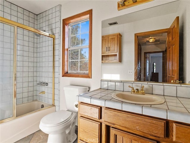 full bathroom featuring toilet, shower / bath combination with glass door, visible vents, and vanity