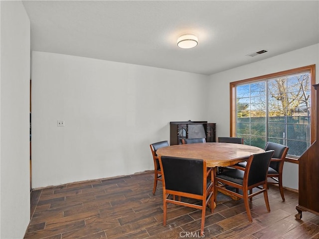 dining space with wood finish floors and visible vents