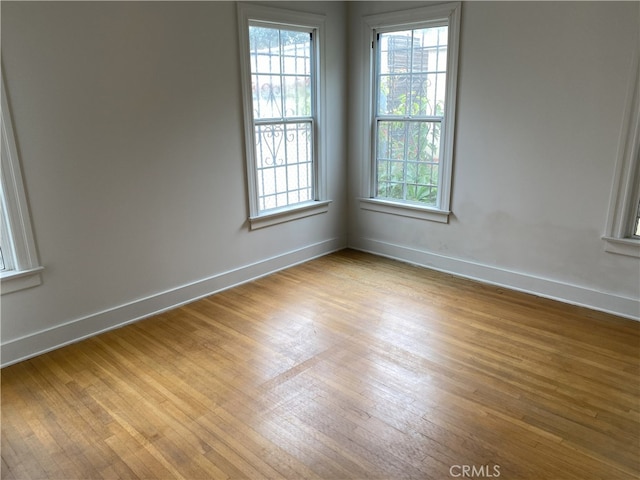 empty room with light wood-style floors and baseboards