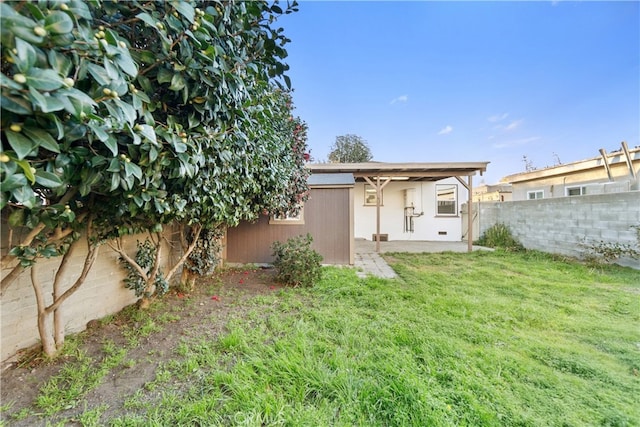 back of house featuring a yard and a fenced backyard