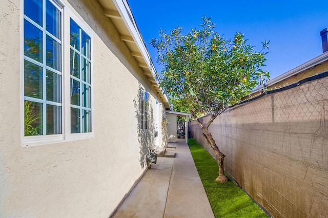 view of property exterior featuring fence and stucco siding