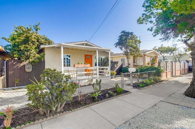 bungalow with a fenced front yard, a gate, a porch, and stucco siding