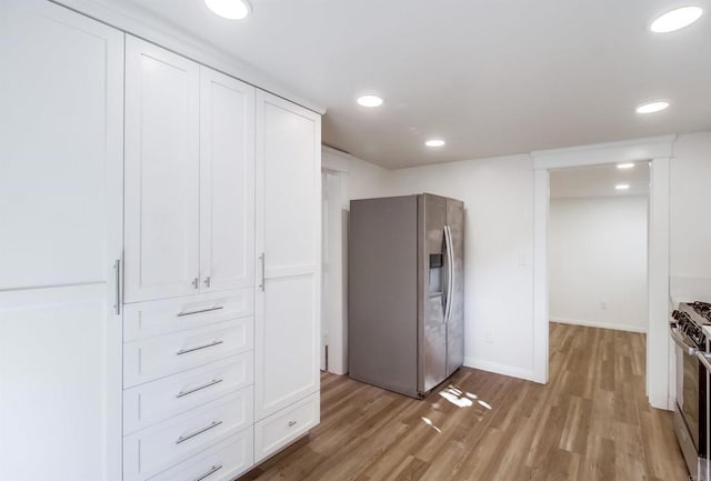 kitchen featuring light wood-style flooring, recessed lighting, white cabinetry, baseboards, and appliances with stainless steel finishes