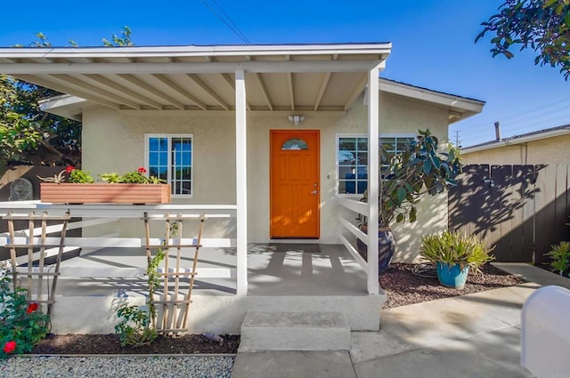 property entrance featuring fence and stucco siding