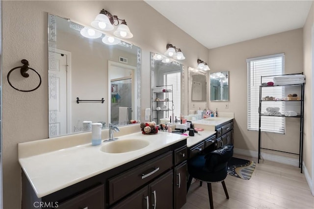 bathroom with visible vents, wood finished floors, vanity, and baseboards