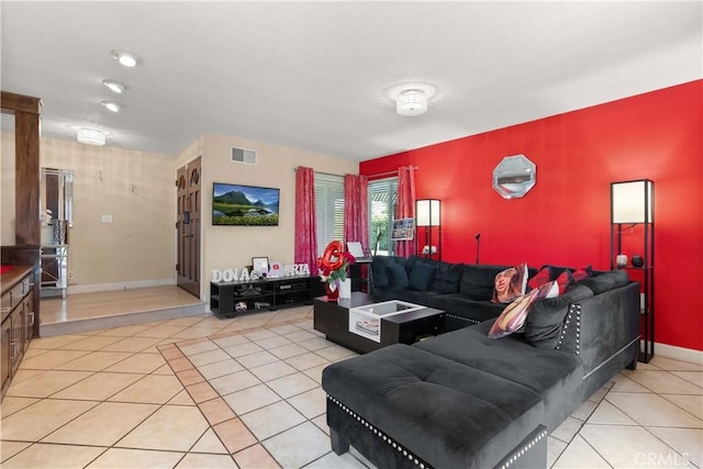 living area with baseboards, visible vents, and light tile patterned flooring