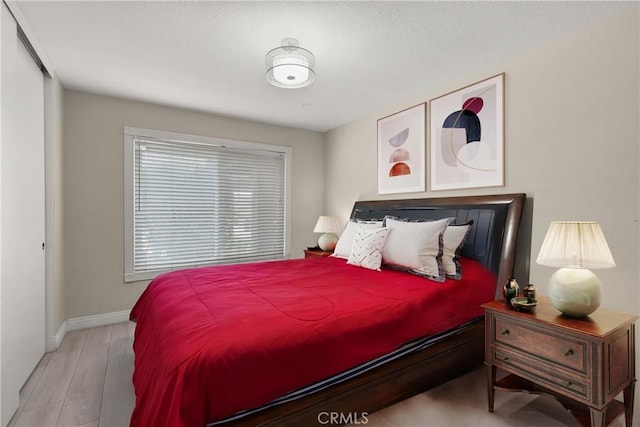 bedroom with wood finished floors and baseboards