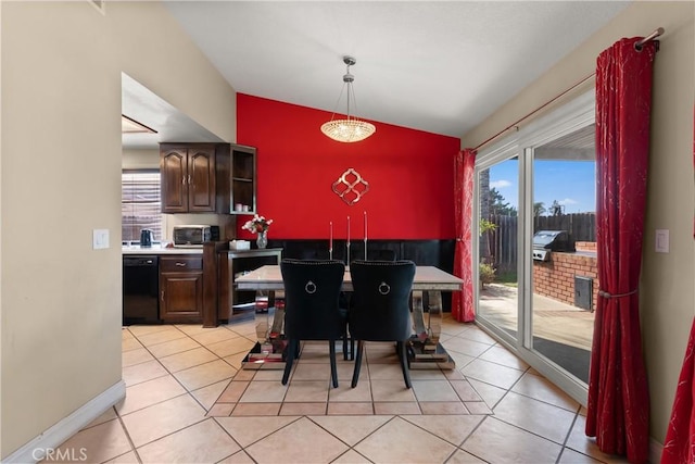 dining room featuring baseboards, vaulted ceiling, and light tile patterned flooring