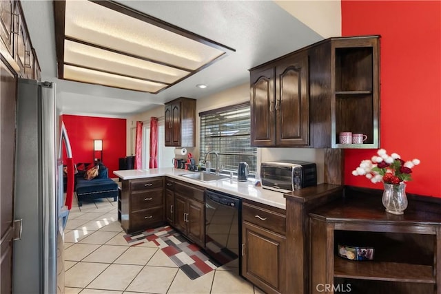 kitchen featuring light tile patterned floors, freestanding refrigerator, a sink, dark brown cabinets, and dishwasher