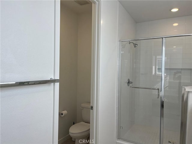 bathroom featuring recessed lighting, a shower stall, and toilet