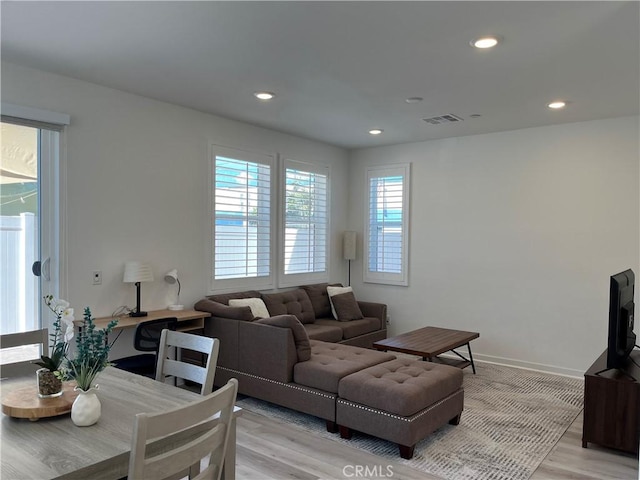 living room with baseboards, light wood-style flooring, visible vents, and recessed lighting