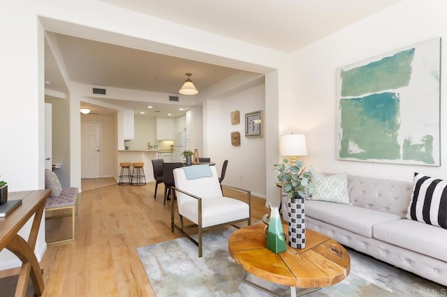 living room featuring light wood-style flooring and visible vents