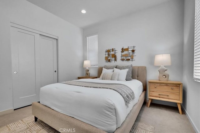 bedroom with recessed lighting, baseboards, a closet, and light colored carpet